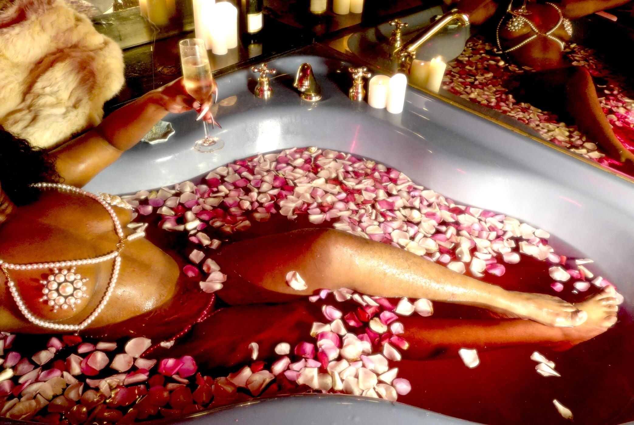 Untitled Black Rotterdam escort, Solana Wood, in pearl lingerie bathes in a blue hot tub filled with rose petals