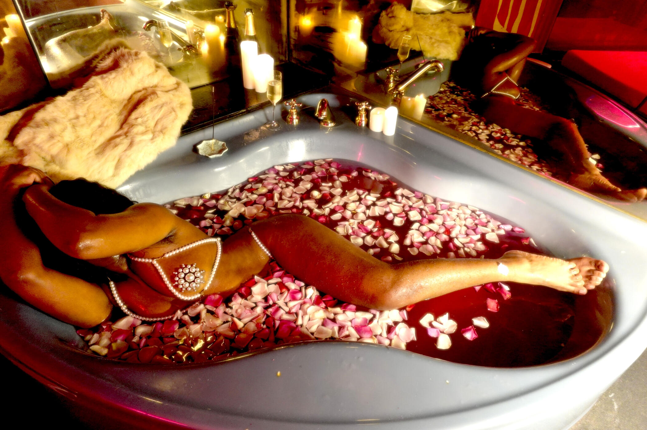 Untitled Black Rotterdam escort, Solana Wood, in pearl lingerie bathes in a blue hot tub filled with rose petals